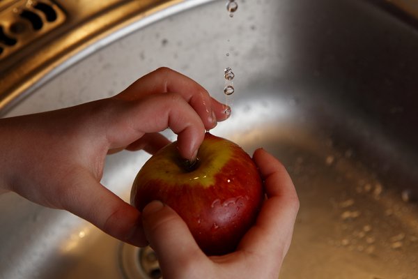 Kinder-Hände waschen einen Apfel