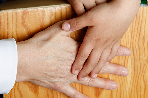 Eine Kinder-Hand und eine erwachsene Hand trommeln