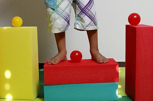 Kinder-Füße stehen auf Bauklötzen